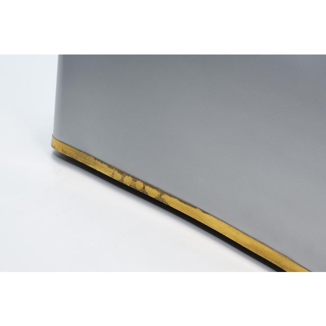 This sculptural table by John Dickinson is crafted from galvanized steel, meticulously formed to resemble flowing draped...