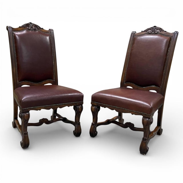 Pair of 2 dining chairs by Henredon. Features an exposed wood frame with finely carved details. Shapely carved legs are...