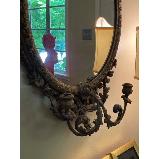 Fine Giltwood and gilded gesso girandole mirror. The oval mirror plate is in excellent condition, and is surrounded by a...