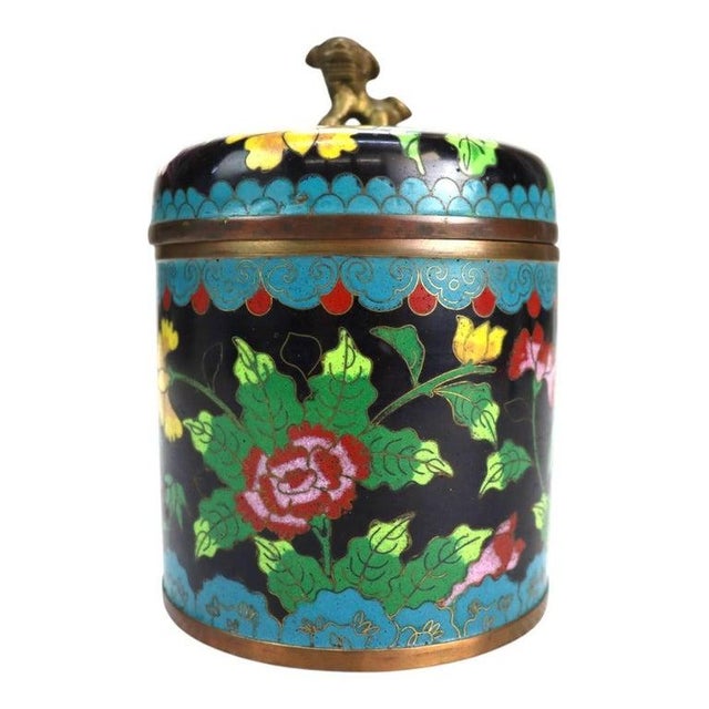 An antique Chinese cloisonné tea caddy, dating to approximately 1920, showcases traditional craftsmanship. This lidded...