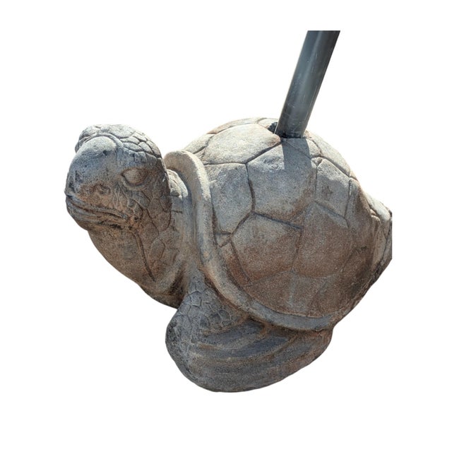A figural concrete tortoise outdoor umbrella base or stand, designed to secure a patio umbrella with its weight, and...