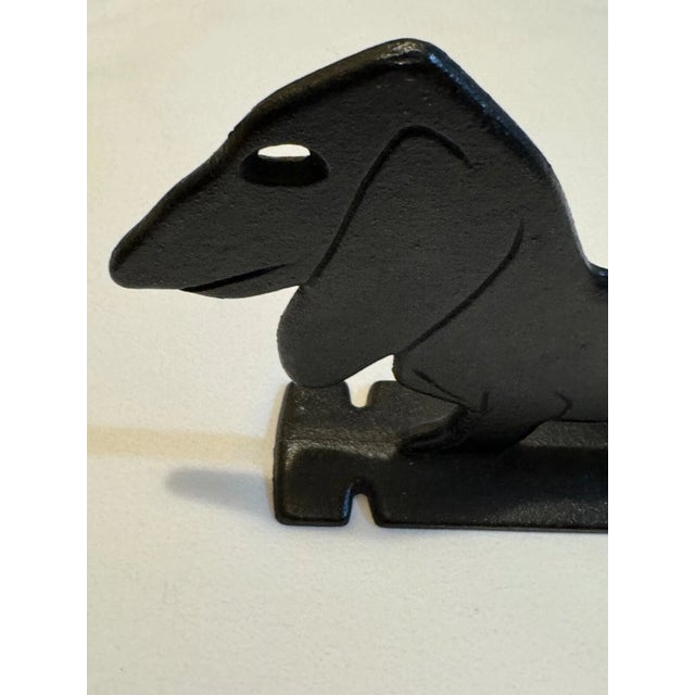 Charming cast iron boot scraper or doorstop in the form of a long-bodied Dachshund with floppy ears, short legs and a...