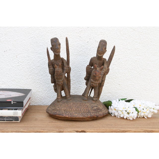 This antique Benin sculpture, carved from wood with a beautifully oxidized patina, depicts two warriors mounted on a...