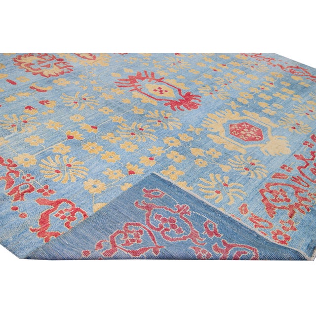 Beautiful modern Oushak hand-knotted wool rug with a blue field. This Oushak rug has a yellow and red accents layout a...