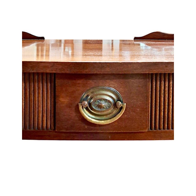 On offer is a George III-style tea table featuring a scalloped gallery with two functional pull-out trays and a small but...