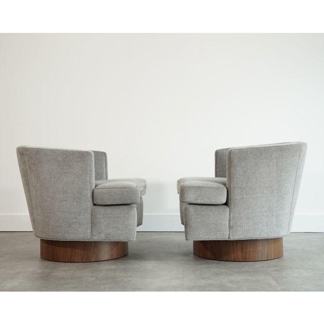 This refined pair of lounge chairs showcases a beautifully sculpted silhouette upholstered in a sophisticated grey woven...