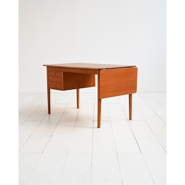 Scandinavian teak desk with a 35 cm side flap and a built-in three-drawer chest. Scandinavian teak desk from the 1960s....