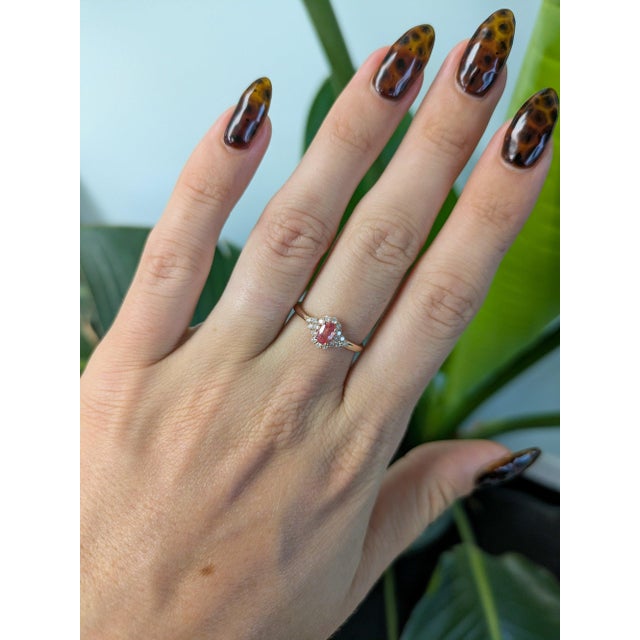 A rare AAA padparadscha sapphire glows in its signature pink-orange at the centre of this solid 14K rose gold ring,...
