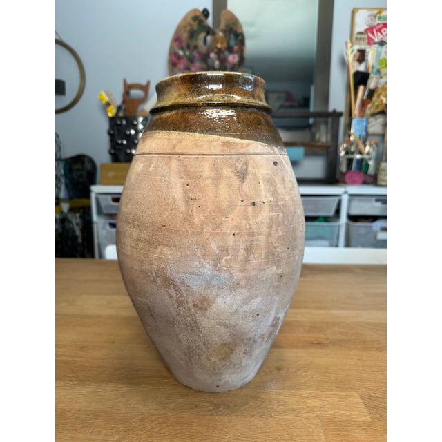 A beautiful asymmetrical design of olive, dark green and brown colored colored glossy glaze adorns the top of this vase...