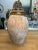 A beautiful asymmetrical design of olive, dark green and brown colored colored glossy glaze adorns the top of this vase...