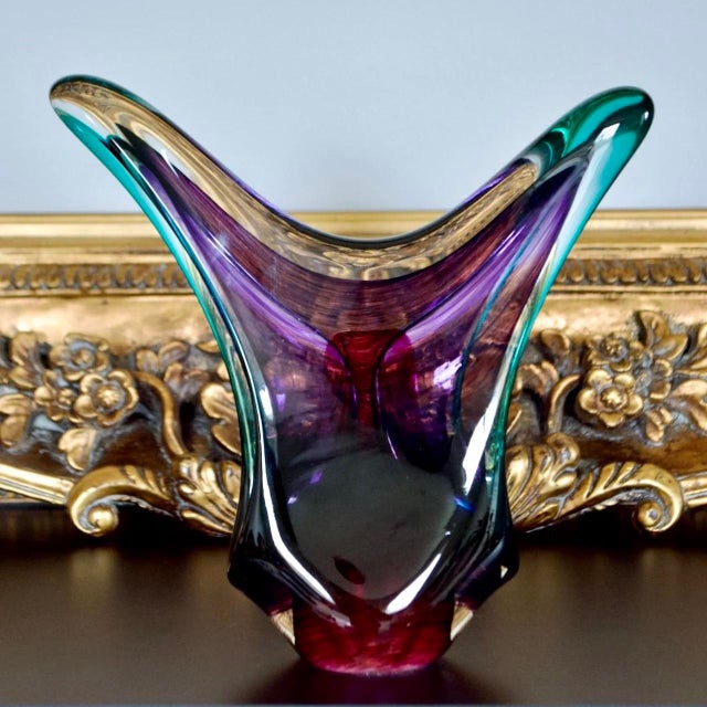 Bold contemporary studio glass sculpture by Joseph Nielander, featuring a fluid gestural form in layered amethyst, teal,...