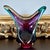 Bold contemporary studio glass sculpture by Joseph Nielander, featuring a fluid gestural form in layered amethyst, teal,...