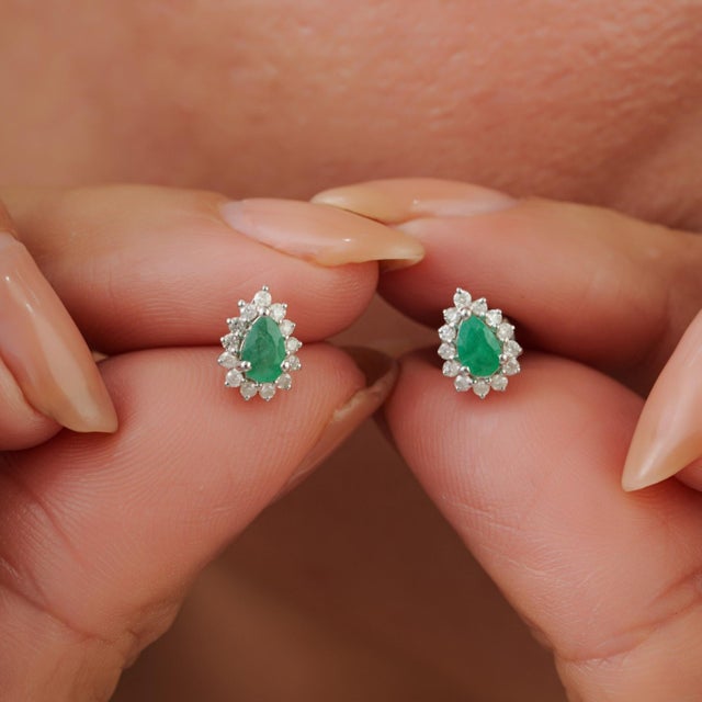 Elegant vintage-style stud earrings featuring natural pear-shaped emeralds set in 925 sterling silver. Each emerald is...