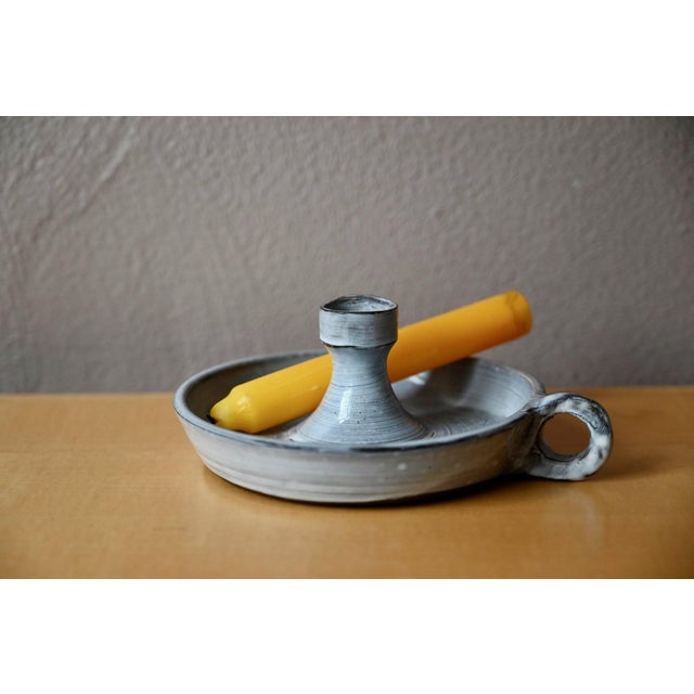 This ceramic candlestick evokes the cozy evenings by candlelight and the meticulous craftsmanship of a skilled potter....