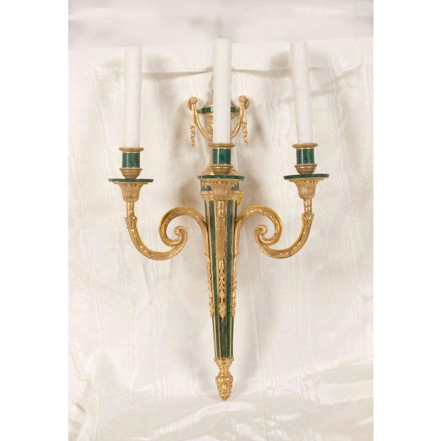 Louis XVI style, hand chased gilded bronze and malachite three-light sconces.