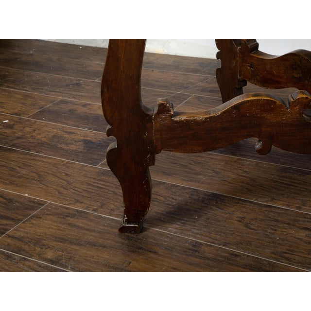 An Italian Baroque style walnut console table from the 18th century, with marquetry geometric top and carved base. Created...