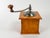 Vintage manual coffee grinder produced by Japy Frères, featuring a solid wooden body, metal hopper, and original hand-...