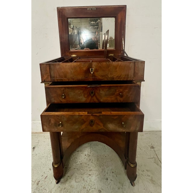 Empire period mahogany and veneer dressing table Two columned uprights on the front Low curved stretcher Two drawers below...