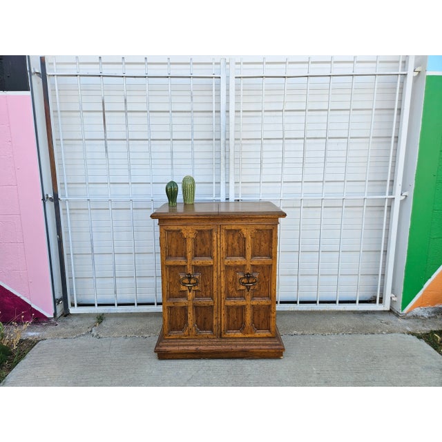 Compact yet bold, this Heritage Furniture buffet cabinet features raised geometric panel doors with oversized iron ring...