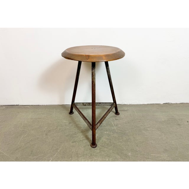 Vintage Industrial factory stool made in former Czechoslovakia during the 1960s It features a brown wooden seat and a grey...