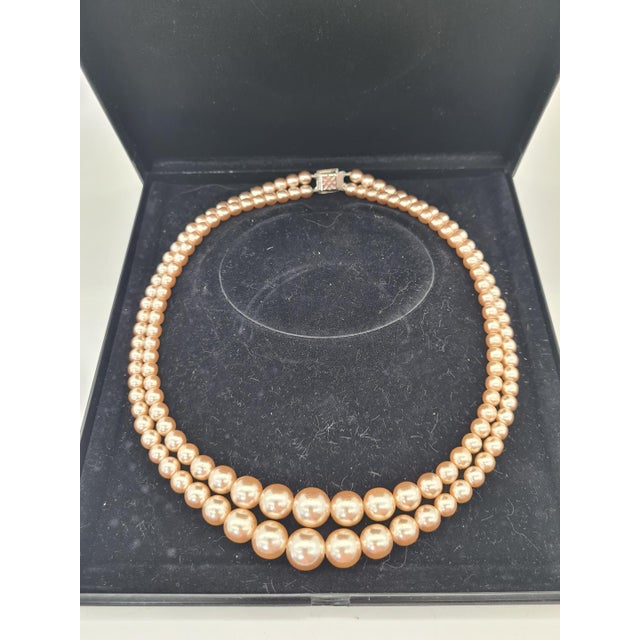 An elegant double-strand pearl necklace, presented in its original Monet brand case. The classic composition of two...