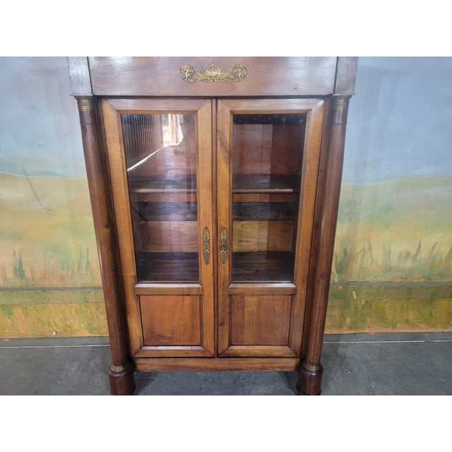 Small Empire-style bookcase, 19th century Elegant small bookcase/display cabinet in solid cherry wood, opening at the...