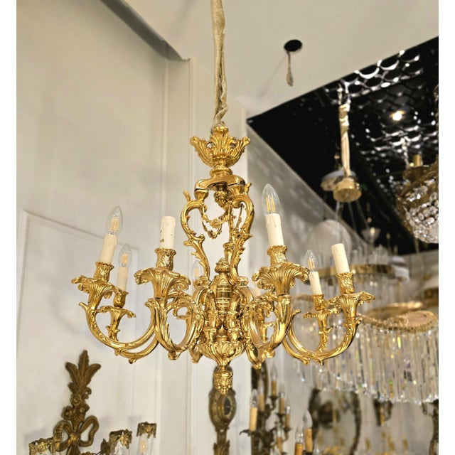 This one-of-a-kind chandelier blends grand sophistication with exquisite detail. Featuring sculpted bronze arms, it casts...