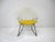 A white coated sculptural welded wire Diamond lounge chair with contrasting satin black steel base and sunflower yellow...