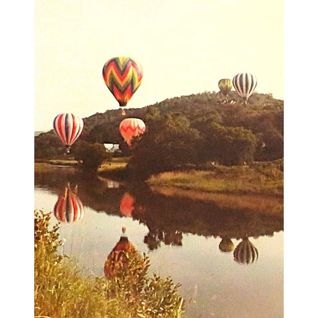 FREE SHIPPING ANYWHERE IN THE CONTINENTAL US! This is a placid photo of colorful hot air balloons floating over a rural...