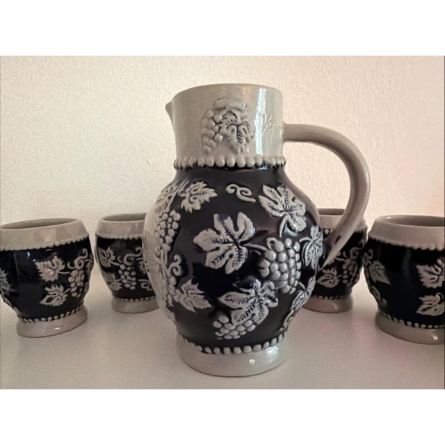 This vintage German stoneware wine set includes a pitcher and six cups, perfect for serving wine in a traditional and...