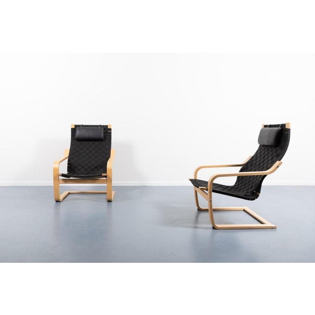 Set of 2 lounge chairs from 1990s with a bend maple frame and black woven canvas seat, equipped with black leather...