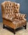 A fine English wingback armchair or library lounge chair - upholstered in tanned leather in the George III style -...