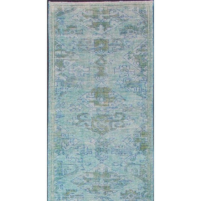 This modern Indian Oushak rug has been hand-knotted in wool and features an all-over, sub-geometric design rendered in...
