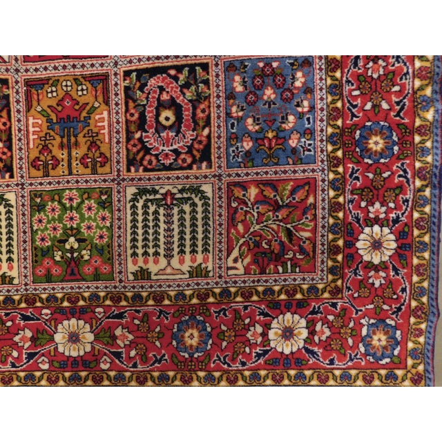Rich in tone rug displaying garden panel within floral decorated red border. Lush wool pile on cotton foundation. A rare find