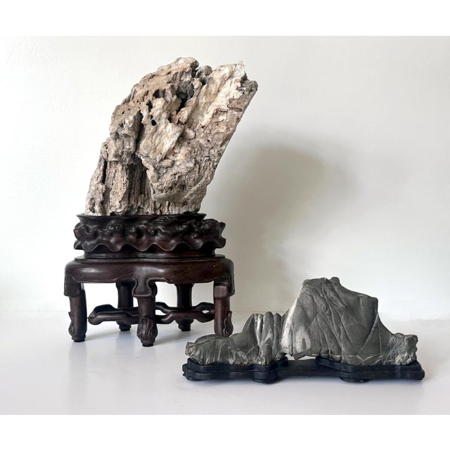 A rare Xuan type Chinese scholar stone on a carved wood stand circa 19th century Qing dynasty. Xuan stone was...