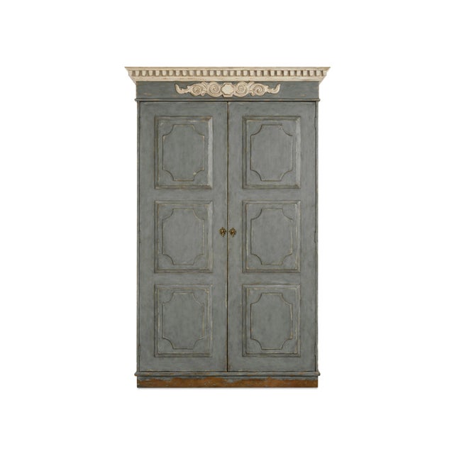 The 19th-century inspired wardrobe featuring a neoclassical dental molding cornice and raised panel doors reflects the...
