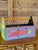 A cheerful vintage wooden caddy featuring whimsical hand-painted fish, colorful geometric accents, and a striped carrying...