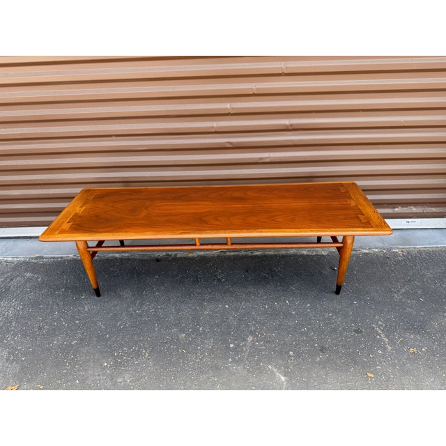 Vintage MCM walnut coffee table from the famed Acclaim series designed by Andre Bus for Lane Furniture. This table has...