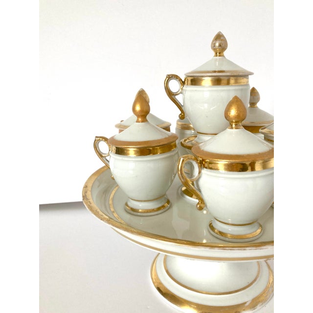 Early 19c set of porcelaine de paris stand and cream pots with covers. Set of Six cream pots and covers with a stand and...