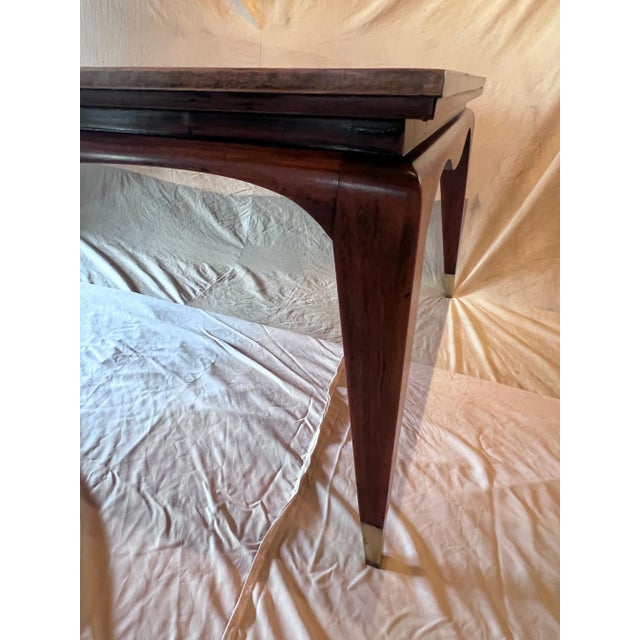 A wonderful expandable Mahogany dining table in the style of James Mont. The tale has an Asian influent with the curvature...