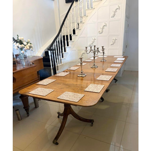 A fine quality Regency mahogany three pillar extending dining table of impressive scale and elegant proportion. The top is...