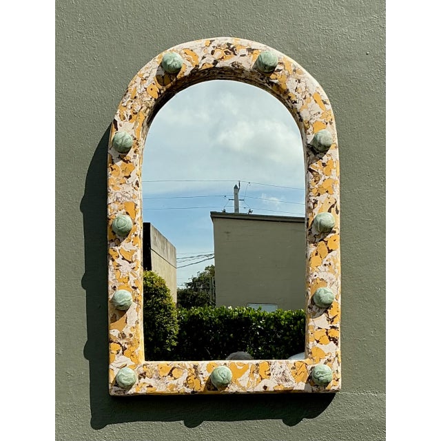 Exemplifying mid-century Italian artistry, this vintage wall mirror is crafted using the traditional scagliola technique...