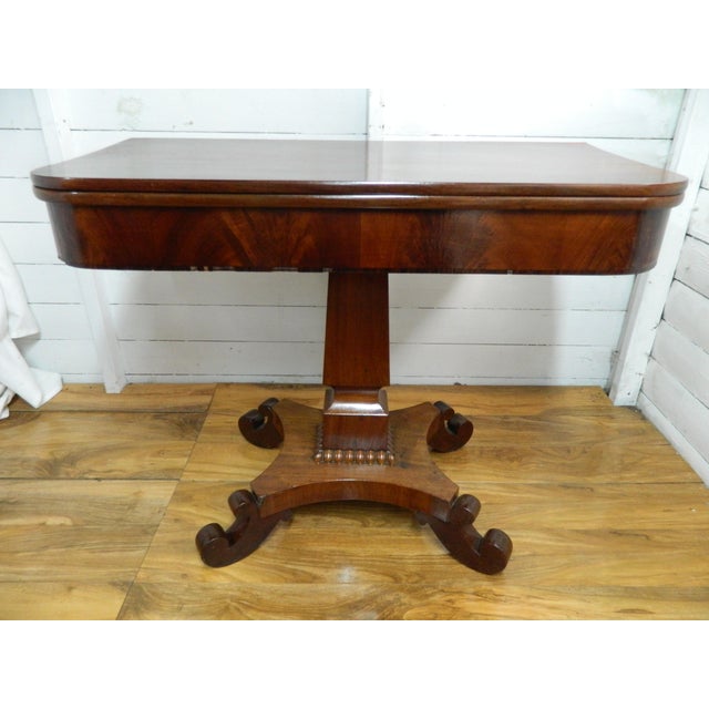 This antique rosewood games table boasts a fold-over lid and card-playing area, perfect for enjoying leisurely evenings...