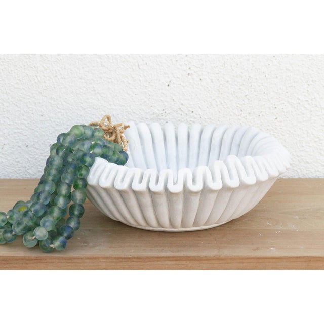 Carved from a single block of pristine white marble, the vessel has been meticulously hand-chiseled to create a continuous...