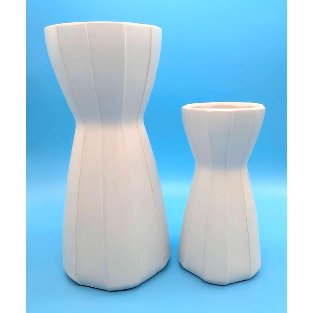Offered are 2 matte white ceramic vases from the "Raya" series designed by Jonathan Adler in the late 1990s for Umbra. The...