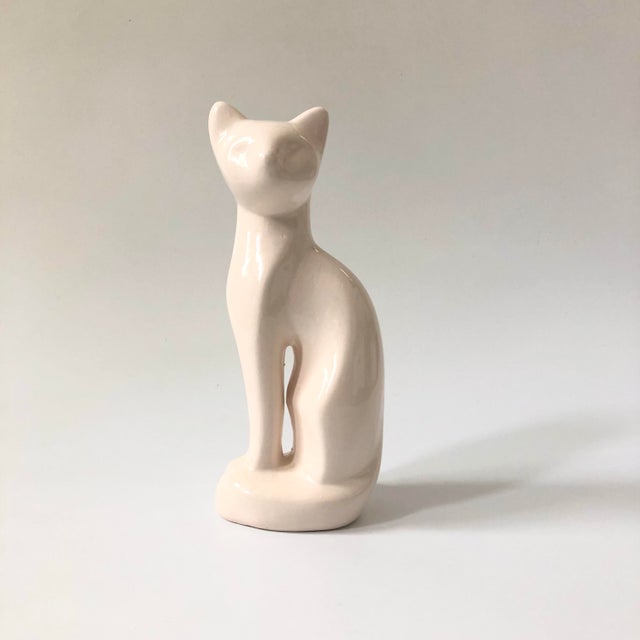 A vintage ceramic cat. Elegant posture with simplified stylized details to the cat's features. Finished in a glossy white...