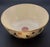 Large deep Chinese bowl in cream with black and red Chinese writing and symbols. The bowl has a metallic gold gilt rim and...