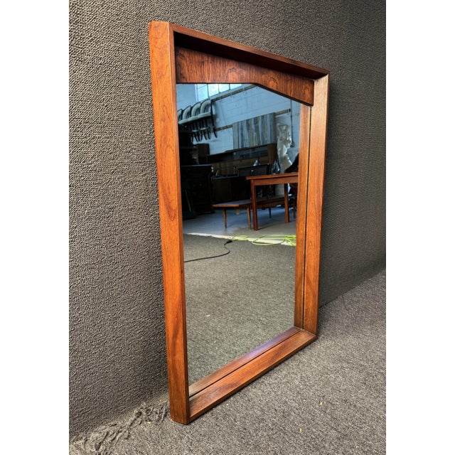 Mid-Century Modern Kent Coffey Wall Mirror. Featuring a straight line rectangular design with curved top, solid wood...
