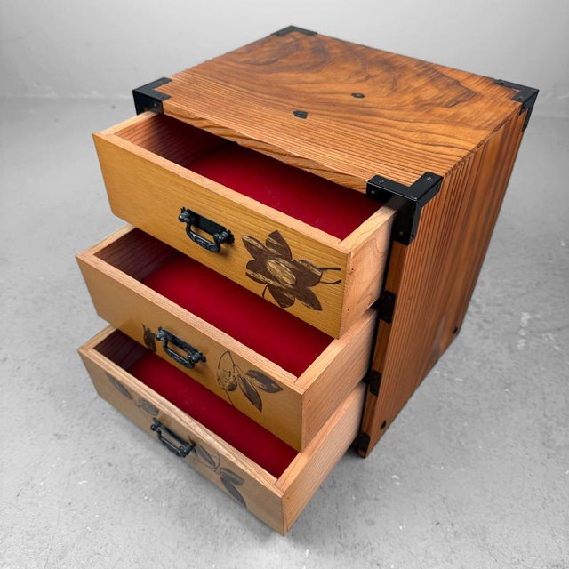 This jewelry chest from the 1980s is made from beautifully grained wood and finished with metal corner fittings and...