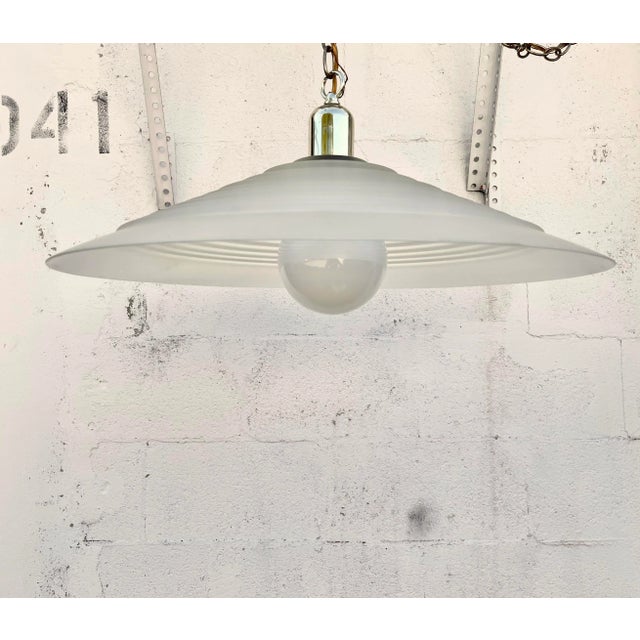 Large Vintage Mid Century Modern Ribbed Glass Ceiling Pendant. Circa 1970s. Features an opaque ribbed glass with a brass...